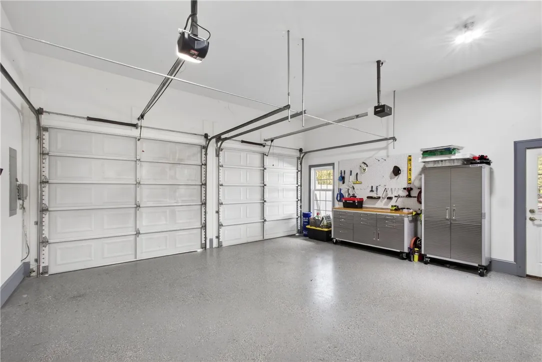 This spacious garage features durable flooring and ample storage, perfect for organization and projects.