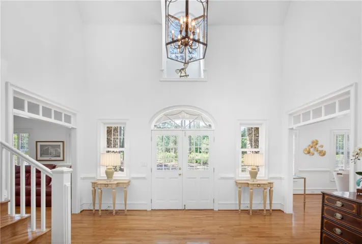 This bright and airy foyer welcomes with high ceilings and rich hardwood floors.