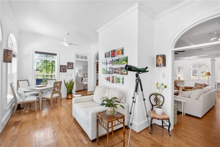 Bright, open-concept living and dining spaces feature gleaming hardwood floors and elegant architectural details.