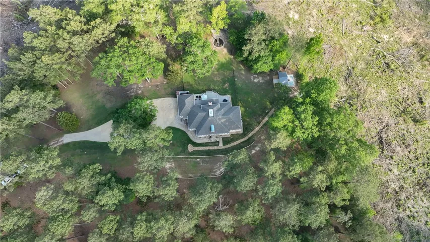 This aerial perspective showcases a secluded estate amidst lush, verdant landscapes.