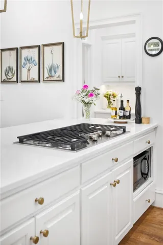 This modern kitchen features crisp white cabinetry, sleek countertops, and a built-in gas range.