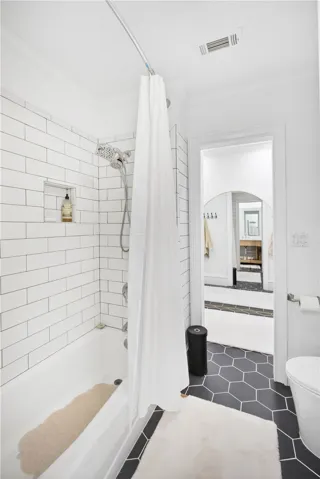 This sleek bathroom features classic subway tile and striking hexagonal floor tiles.