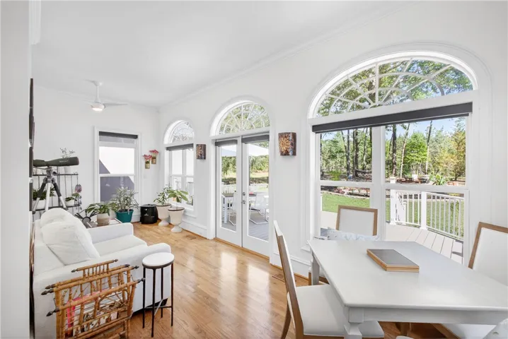Bright and airy living space with expansive windows provides serene views of the surrounding natural landscape.