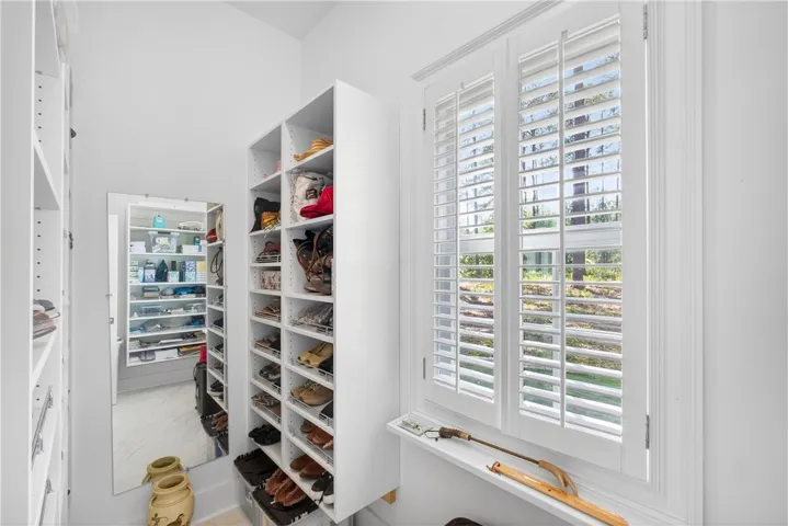 This spacious walk-in closet offers extensive built-in shelving and natural light.