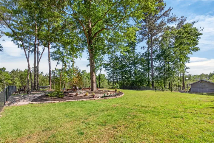 This spacious yard offers a serene retreat with mature trees and ample green space for outdoor enjoyment.