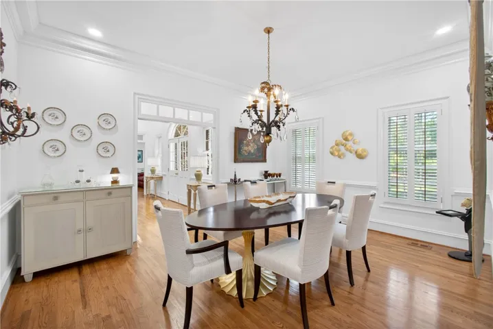 This dining room offers hardwood flooring, crown molding, and bright windows, perfect for entertaining.