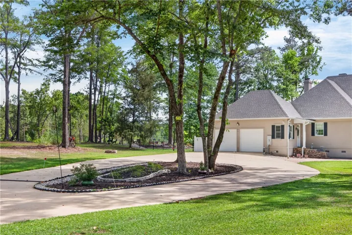 This spacious property boasts a two-car garage and an expansive, lush lawn.