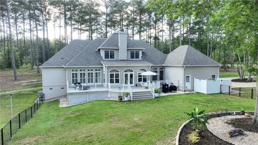 This spacious estate features a large deck overlooking a private, wooded backyard.