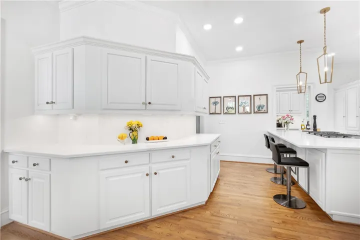 This spacious kitchen offers ample counter space, abundant cabinetry, and durable hardwood flooring.
