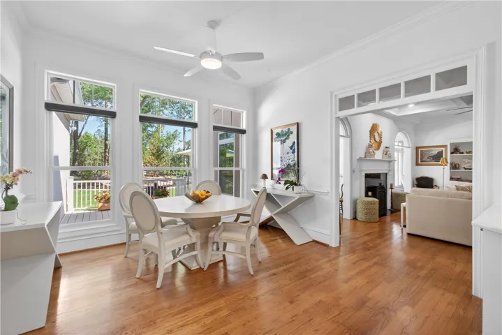 This bright dining area features expansive windows, crown molding, and polished hardwood floors.