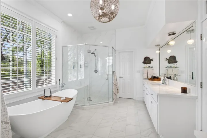 This tranquil bathroom features a freestanding tub and a spacious glass-enclosed shower.