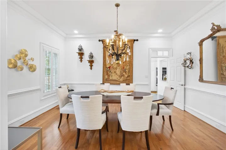 This elegant room features hardwood flooring, crown molding, and recessed lighting, perfect for formal gatherings.