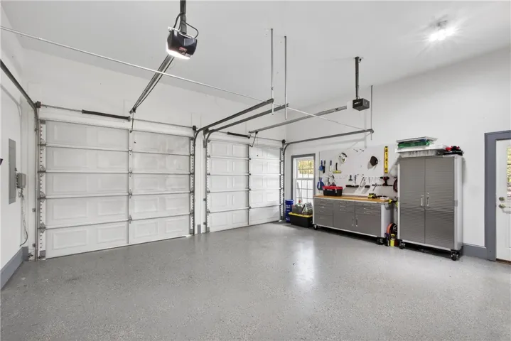 This spacious garage features durable flooring and ample storage, perfect for organization and projects.