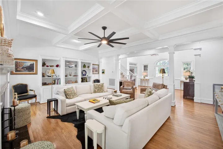 This bright living space features hardwood floors and a striking coffered ceiling, perfect for comfortable gatherings.