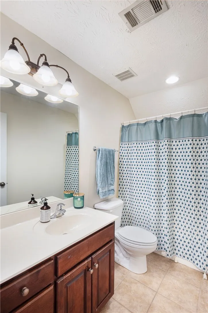 This bathroom features a functional layout with a vanity, toilet, and shower.