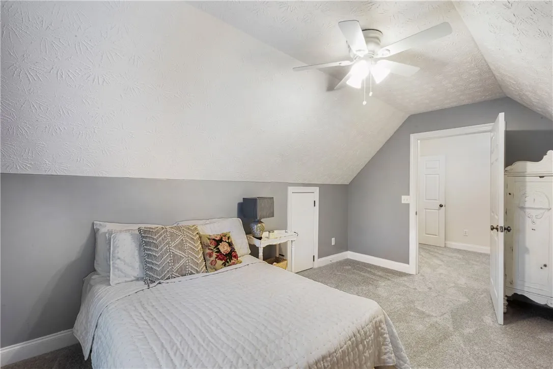 Comfortable bedroom with sloped ceilings and ample space, creating a cozy and inviting atmosphere.