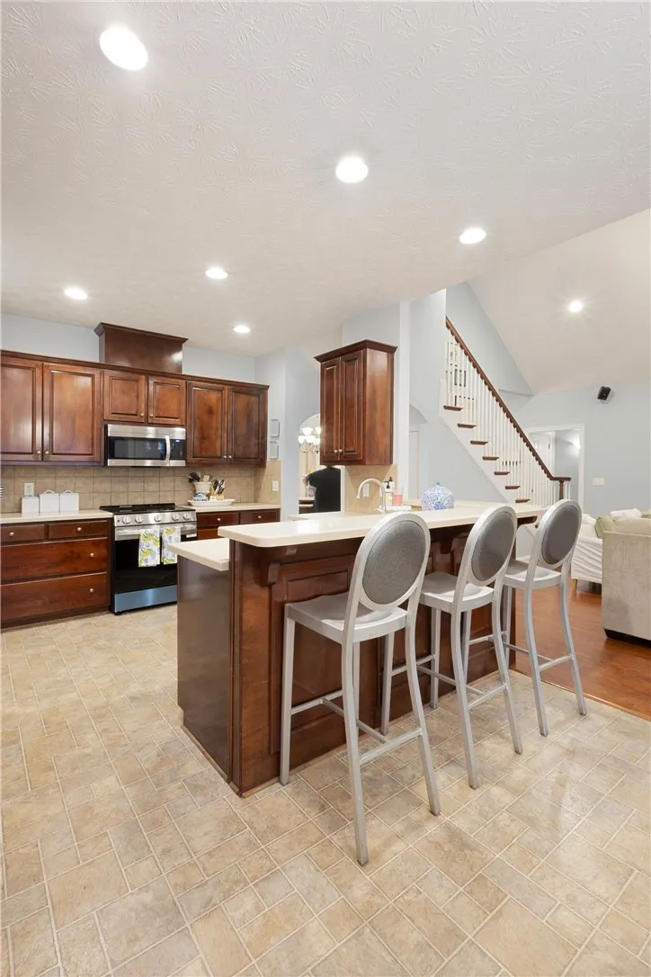 This spacious kitchen offers a functional layout with direct access to an elegant staircase.