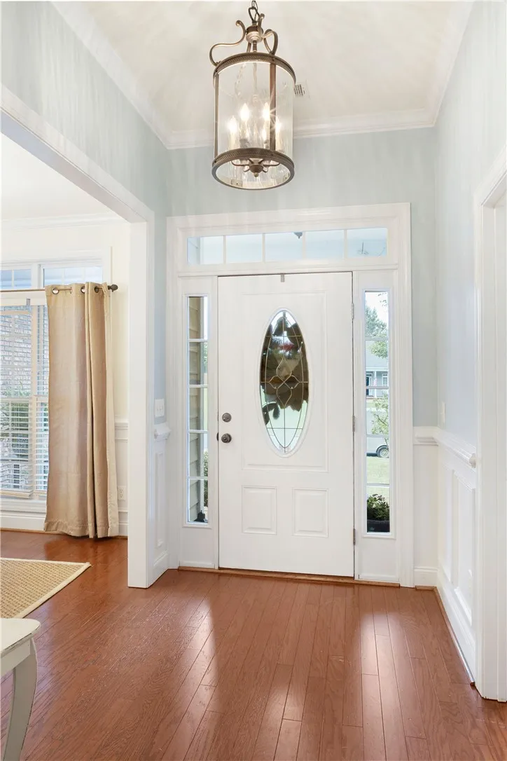 Step into this welcoming entryway featuring warm hardwood flooring and crown molding.