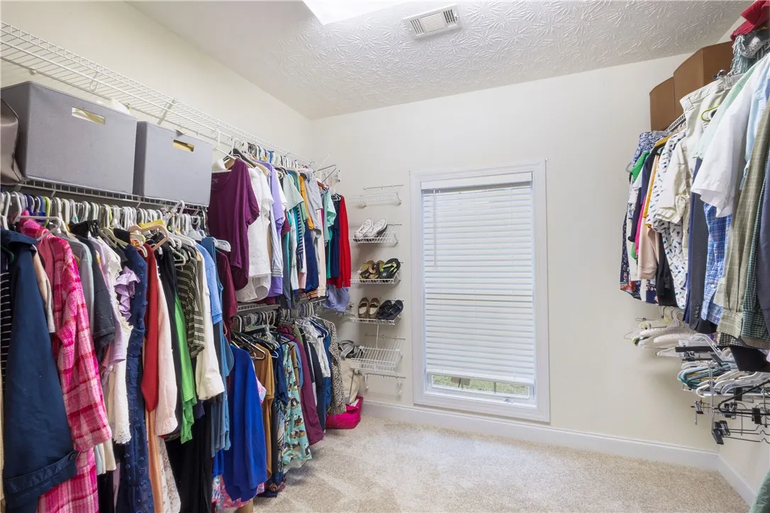This spacious walk-in closet offers extensive storage solutions, perfect for any wardrobe.