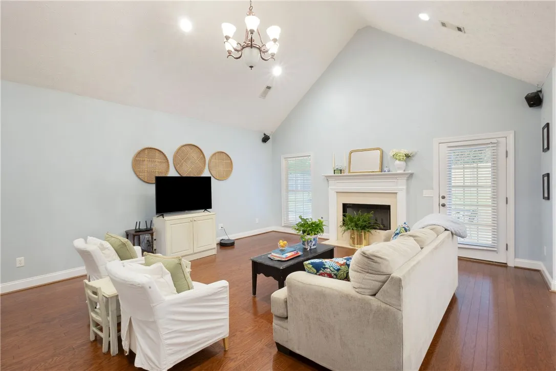 This airy living room features high vaulted ceilings and a classic fireplace.
