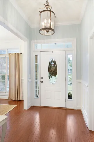 Step into this welcoming entryway featuring warm hardwood flooring and crown molding.