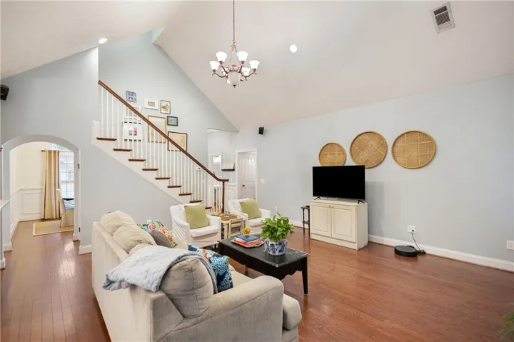 This airy living space features rich hardwood floors and an elegant staircase.