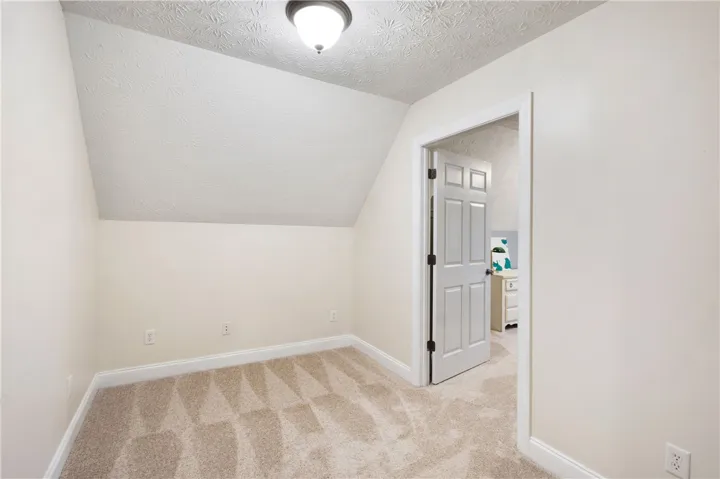 This cozy room features sloped ceilings and plush carpeting, perfect for a private retreat.