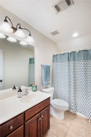 This bathroom features a functional layout with a vanity, toilet, and shower.