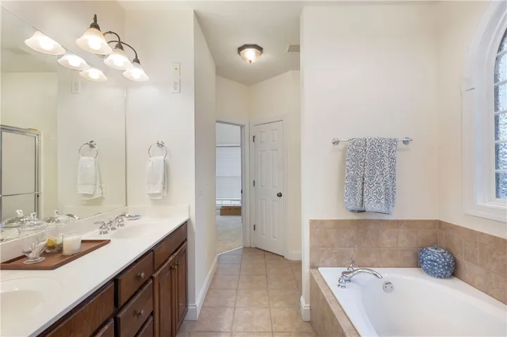 This spacious bathroom offers dual vanities and a relaxing soaking tub.