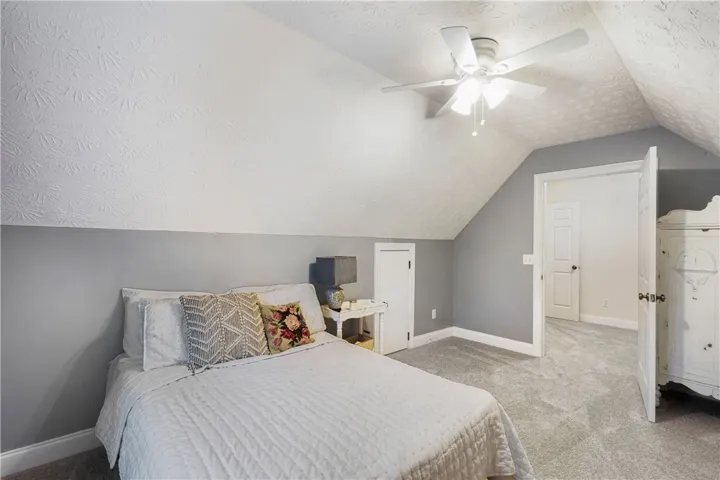 Comfortable bedroom with sloped ceilings and ample space, creating a cozy and inviting atmosphere.