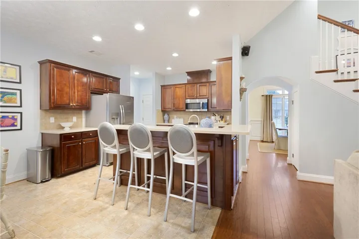 This open kitchen features modern appliances and a functional island, flowing into a warm living area.