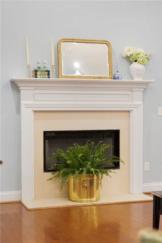 This inviting fireplace creates a focal point, complemented by rich hardwood flooring.