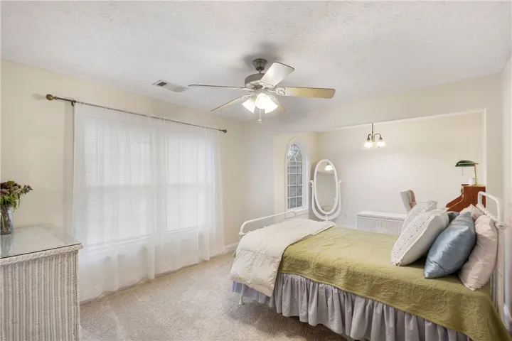 This inviting bedroom offers comfort and natural light through its large windows.