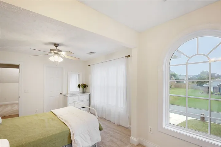 This serene bedroom offers ample light and comfortable living, with a view of the peaceful outdoors.