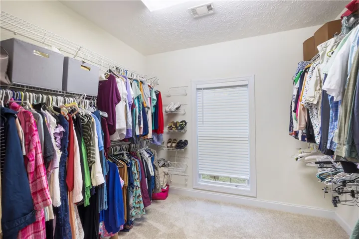 This spacious walk-in closet offers extensive storage solutions, perfect for any wardrobe.