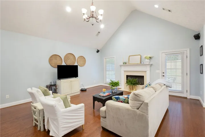 This airy living room features high vaulted ceilings and a classic fireplace.