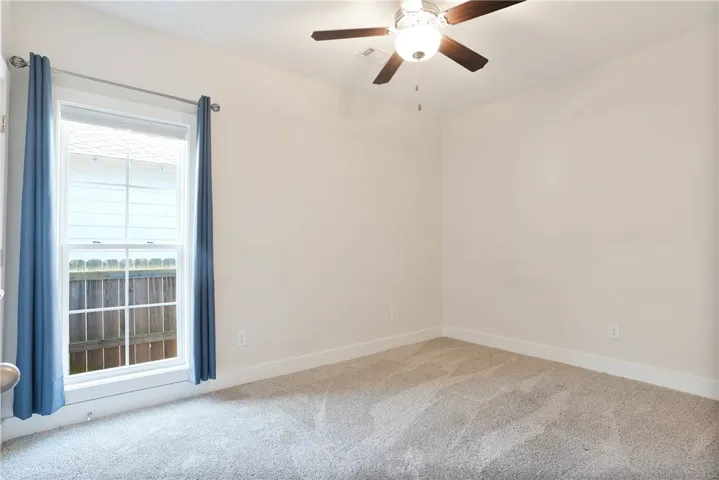 This airy bedroom features plush carpeting and abundant natural light.