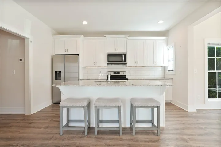 This kitchen features a central island, modern appliances, and sleek countertops, perfect for culinary endeavors.