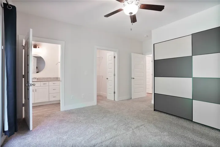 This spacious bedroom offers ample comfort and convenience, with an adjoining bathroom and walk-in closet.
