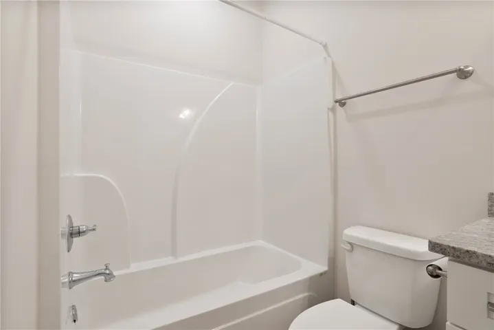 This clean and inviting bathroom offers a convenient shower-tub combination and sleek vanity.