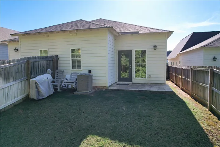Enjoy outdoor living in this private yard with a durable wooden fence and ample space.