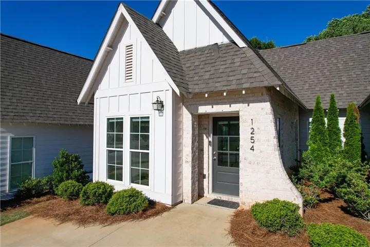 This charming home offers a welcoming facade with attractive landscaping and classic architectural elements.