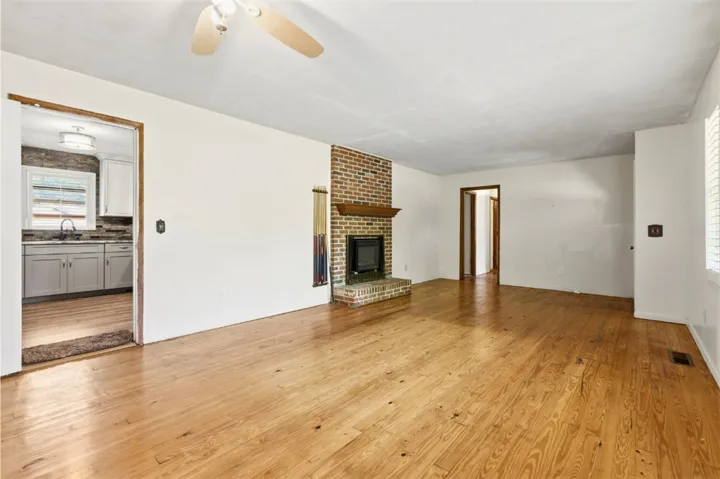 This inviting living area boasts rich hardwood flooring and a charming brick fireplace.