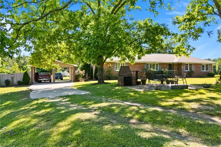 This charming home offers a spacious yard with mature trees and a convenient carport.