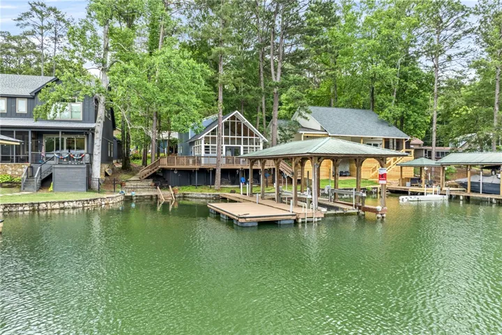 Lakeside living beckons with multiple docks and lush tree-lined privacy.