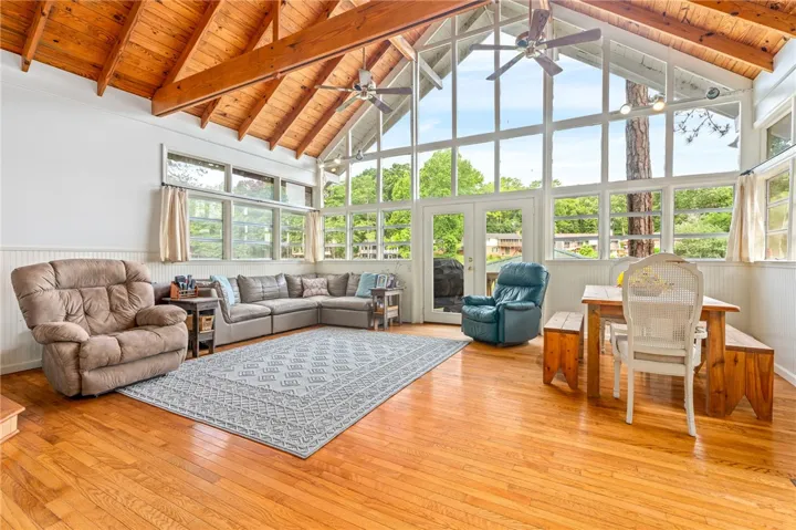 Hardwood floors and soaring vaulted ceilings with exposed beams define this naturally illuminated great room.