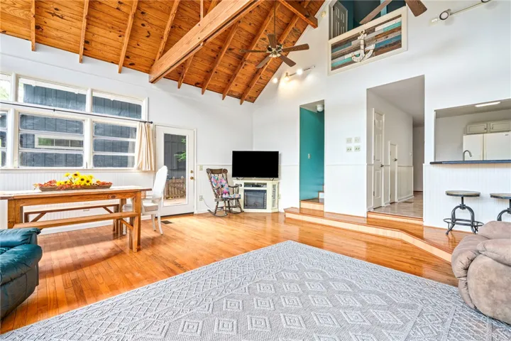 A rustic charm emanates from the vaulted wooden ceilings and polished hardwood floors of this open living space.