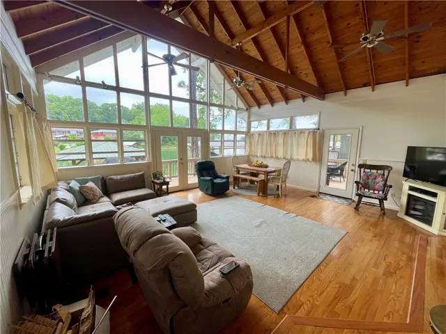 A spacious living area with soaring vaulted ceilings offers natural light and lakeside views.