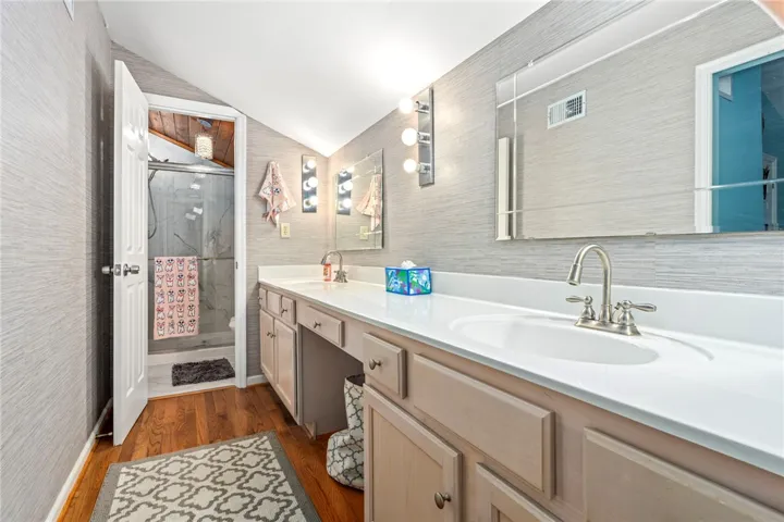 Dual vanities with sleek countertops and abundant lighting create a functional and pleasant bathroom environment.