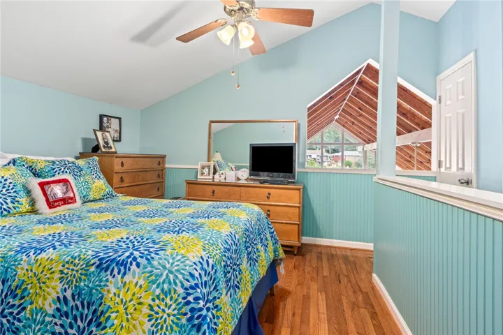 Hardwood floors and vaulted ceilings create an open, airy bedroom retreat.
